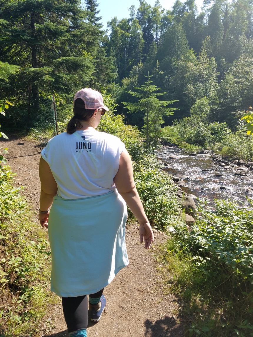 Lindsey Strobel walking on a trail wearing JunoActive plus size activewear.
